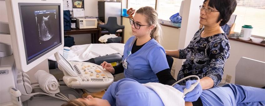 A cardiovascular sonography student working with an instructor to gather a patient's sonogram.