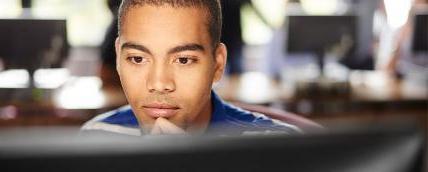 A student looking pensively at a computer screen