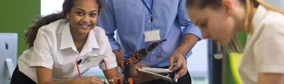 Student and teacher working with robotics in classroom.